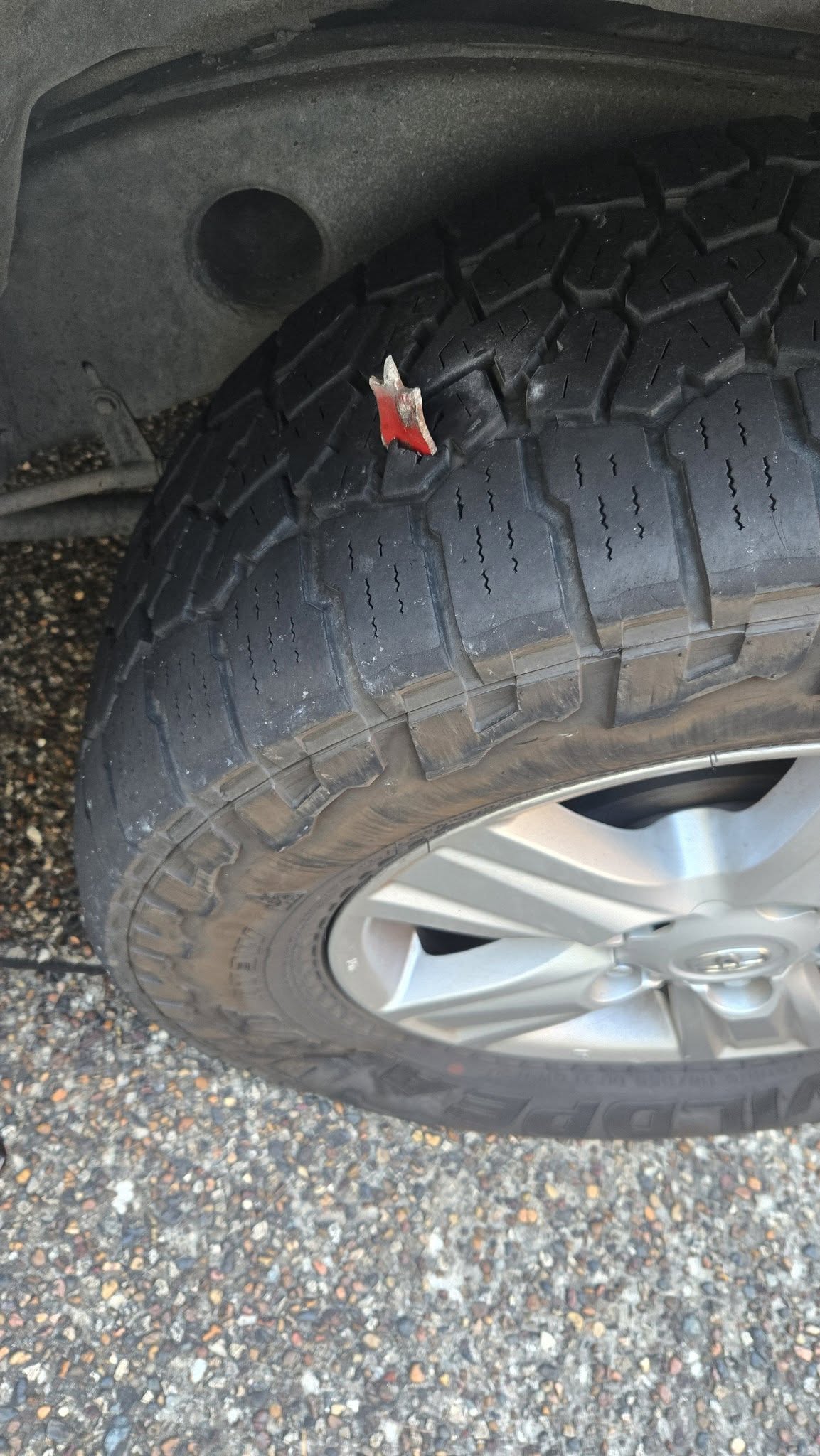 Sharp red metal object embedded in a four-wheel-drive tyre