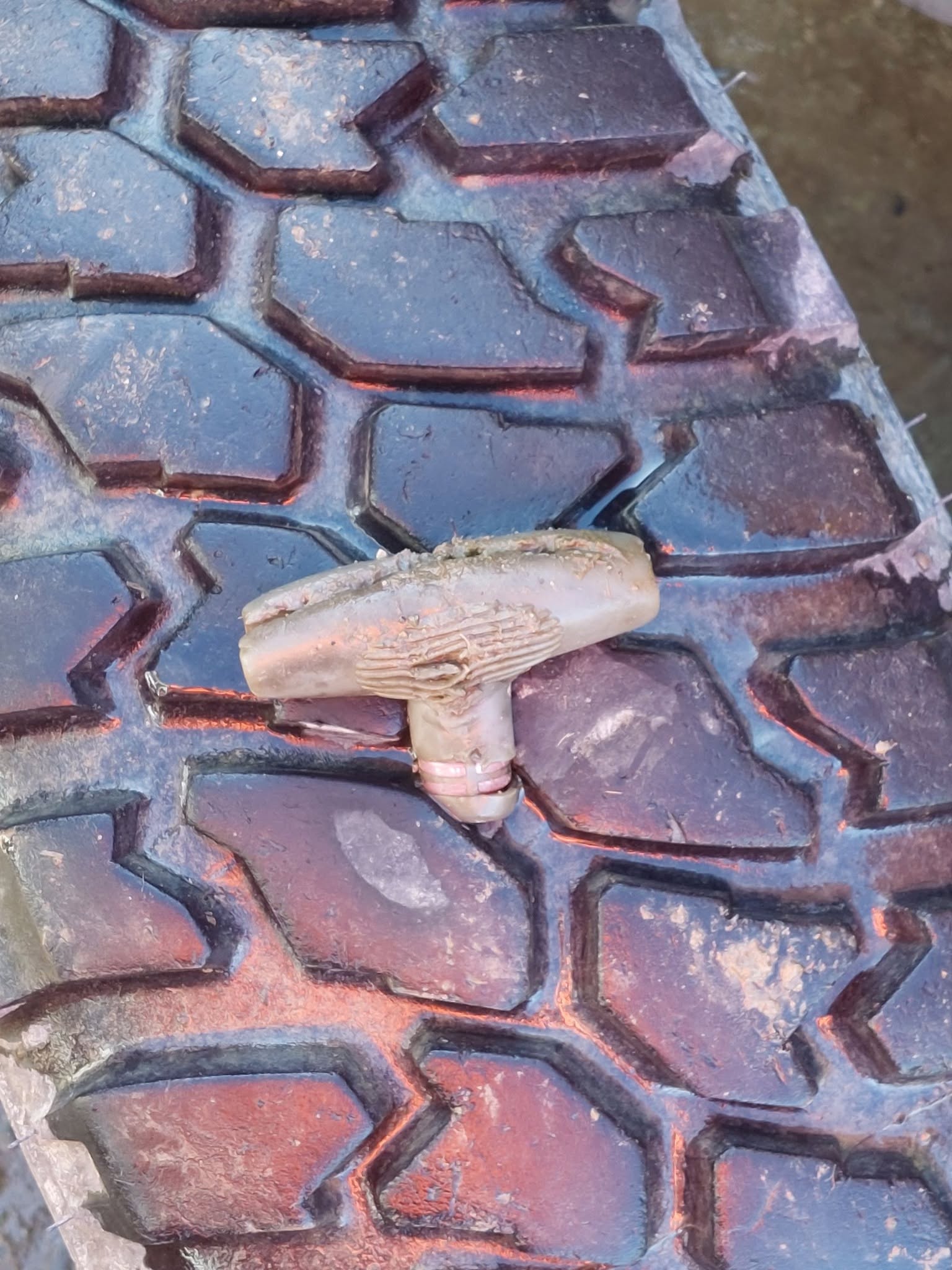 T-handle screwdriver embedded in a vehicle tyre